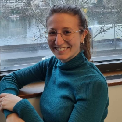 Photo de Florine avec un pull bleu sur fond des quais du Rhône